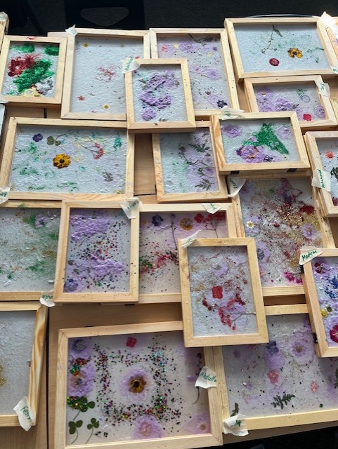 Frames filled with handmade papers decorated with flowers and glitter