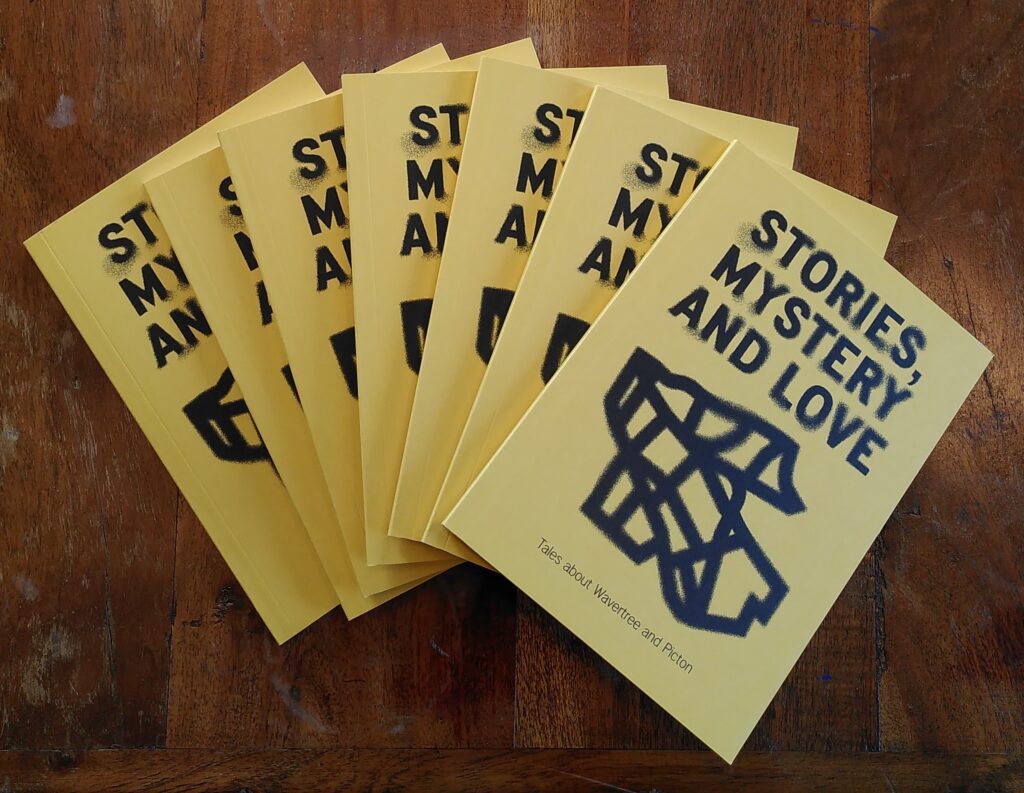 A photo featuring a fan of yellow printed books with bold lettering that read 'Stories, Mystery and Love' with a line drawing of a shape underneath