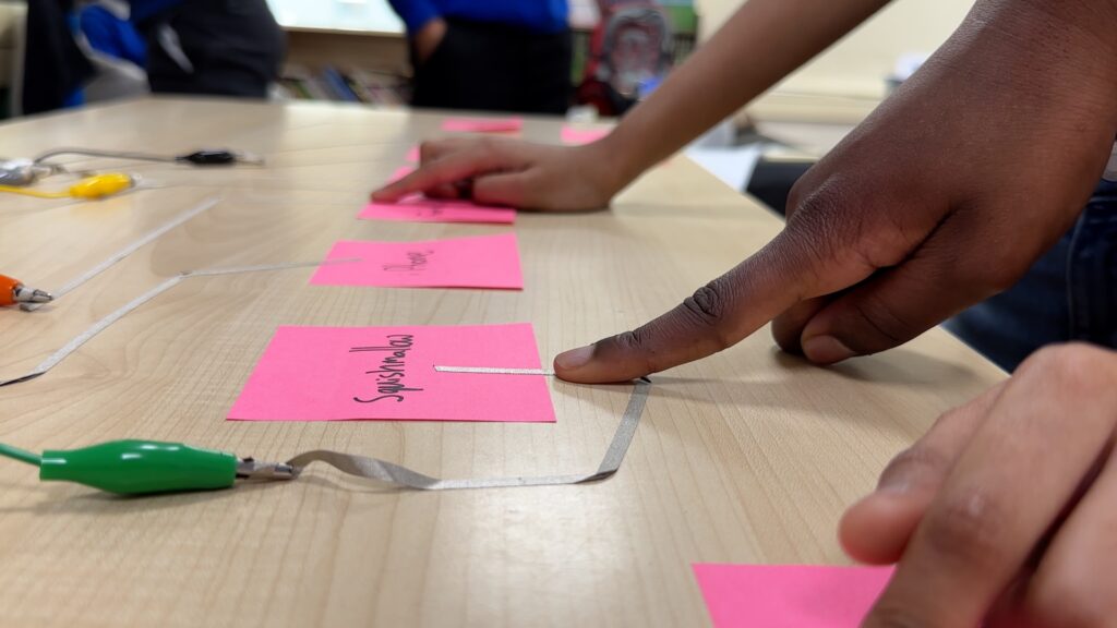 a close up shot of fingers pointing to words written on post its
