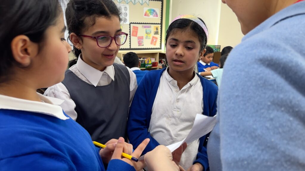 A group of children in uniform in school holding a discussion