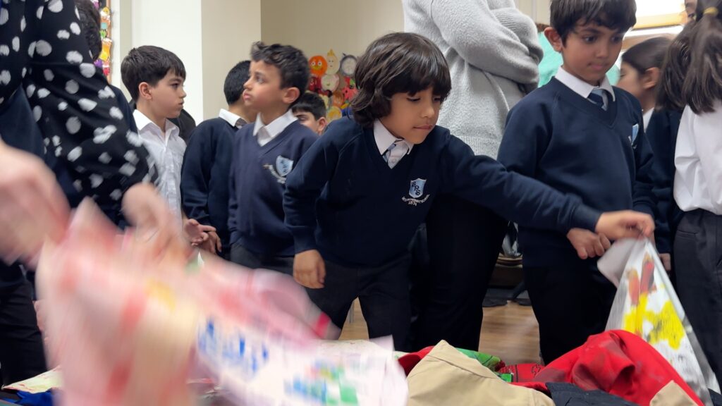 Children in school. uniform are handling painted fabrics